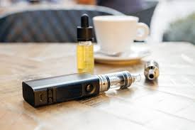 vaping juice, vape pen and cup of tea